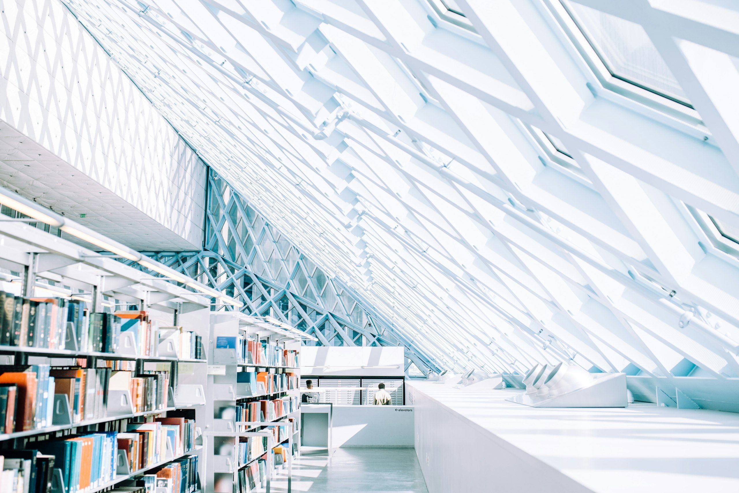 Rows of bookshelves in a bright, white modern library